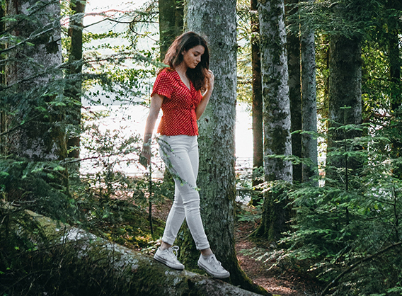 Girl walking on a tree in a forest